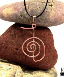 Pendentif en cuivre artisanal représentant le symbole Reiki Cho Ku Rei sur un cordon noir, bijou de guérison énergétique.