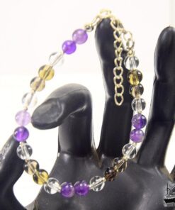 Bracelet artisanal Frida composé de perles violettes d'améthyste, de quartz fumé gris et de cristal de roche avec apprêts argentés.