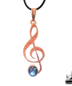 Pendentif artisanal Caden en forme de clé de sol en cuivre avec cabochon de labradorite aux reflets bleutés.