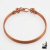 Bracelet jonc artisanal Lucia pour femme en cuivre naturel poli de 19 cm, posé sur un fond inspiré de la nature et de la magie forestière.