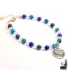 Bracelet artisanal Rhasa composé de perles en cristal de roche, apatite et lapis-lazuli avec une breloque fleur de lotus.