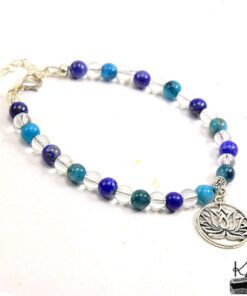 Bracelet artisanal Rhasa composé de perles en cristal de roche, apatite et lapis-lazuli avec une breloque fleur de lotus.