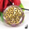 Pendentif orgonite artisanal "Prumen" avec éclats de lépidolite violette et symbole Fleur de Vie en métal, conçu pour la protection énergétique.