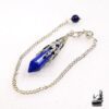 Pendule divinatoire en pierre de Lapis Lazuli facettée de 5,5 cm avec chaînette, posé sur un fond ésotérique pour la pratique de la radiesthésie.