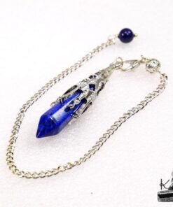 Pendule divinatoire en pierre de Lapis Lazuli facettée de 5,5 cm avec chaînette, posé sur un fond ésotérique pour la pratique de la radiesthésie.
