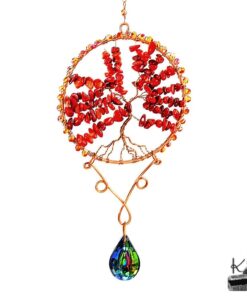 Suncatcher artisanal Finna suspendu à une branche d'arbre, composé de perles de corail rouge et d'un prisme en cristal projetant des reflets arc-en-ciel.
