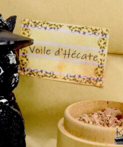 Sachet d'encens rituel Voile d'Hécate avec plantes séchées et résines de protection posé près d'une statuette.