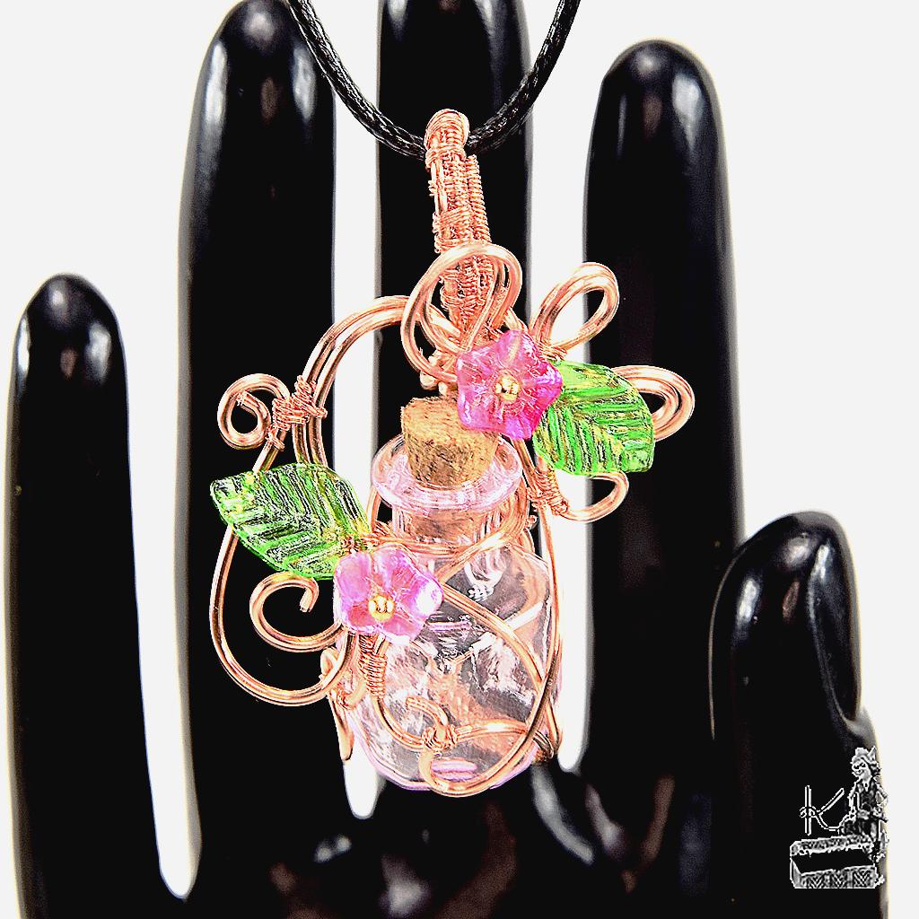 Pendentif artisanal Ophel en cuivre wire wrapped avec fiole en verre et fleurs, création magique unique par Le Trésor des Korriganes.