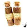 Fiole de poudre d'amour et d'attraction artisanale composée de pétales de rose et d'herbes naturelles pour rituel de sorcellerie positive.