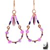 Paire de boucles d'oreilles pendantes artisanales Olier en cuivre naturel et perles en verre tchèque sur fond de nature.