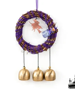 Suspension Witch Bells Sabrina en rotin avec rubans violets, cloches et fiole de sortilège pour la protection de la maison.