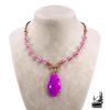 Collier bohème artisanal Galla en cuivre naturel et cabochon en agate bandée posé sur un fond inspiré de la nature.