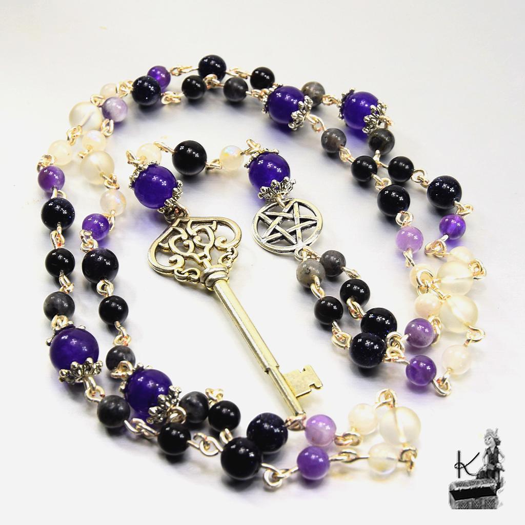 Rosaire magique d'Hécate en pierres naturelles avec clé argentée et pentacle pour rituels ésotériques et méditation sur un autel.
