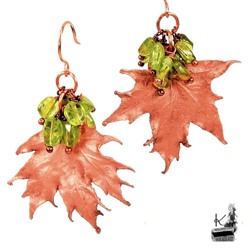 Boucles d'oreilles pendantes artisanales Aradia en cuivre avec de véritables feuilles d'érable électroformées et des perles de péridot.