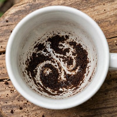 Tasse de thé en porcelaine blanche avec des feuilles de thé au fond pour la pratique de la taséographie et de la divination.