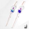 Gros plan sur un bijou d'oreille artisanal Bugadi Heri en cuivre martelé pour oreilles percées, orné d'une lune en pierre de lune et d'une étoile en verre violet