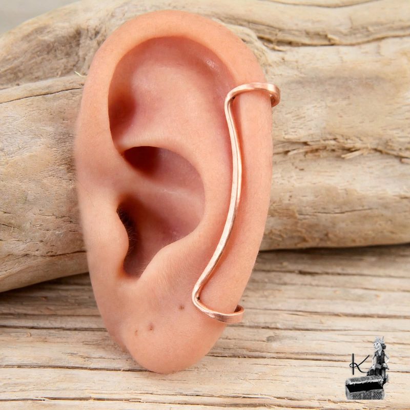 Ear cuff tour d'oreille "Fil d'Aurore" en cuivre pur cisclé, présenté sur le pavillon de l'oreille.
