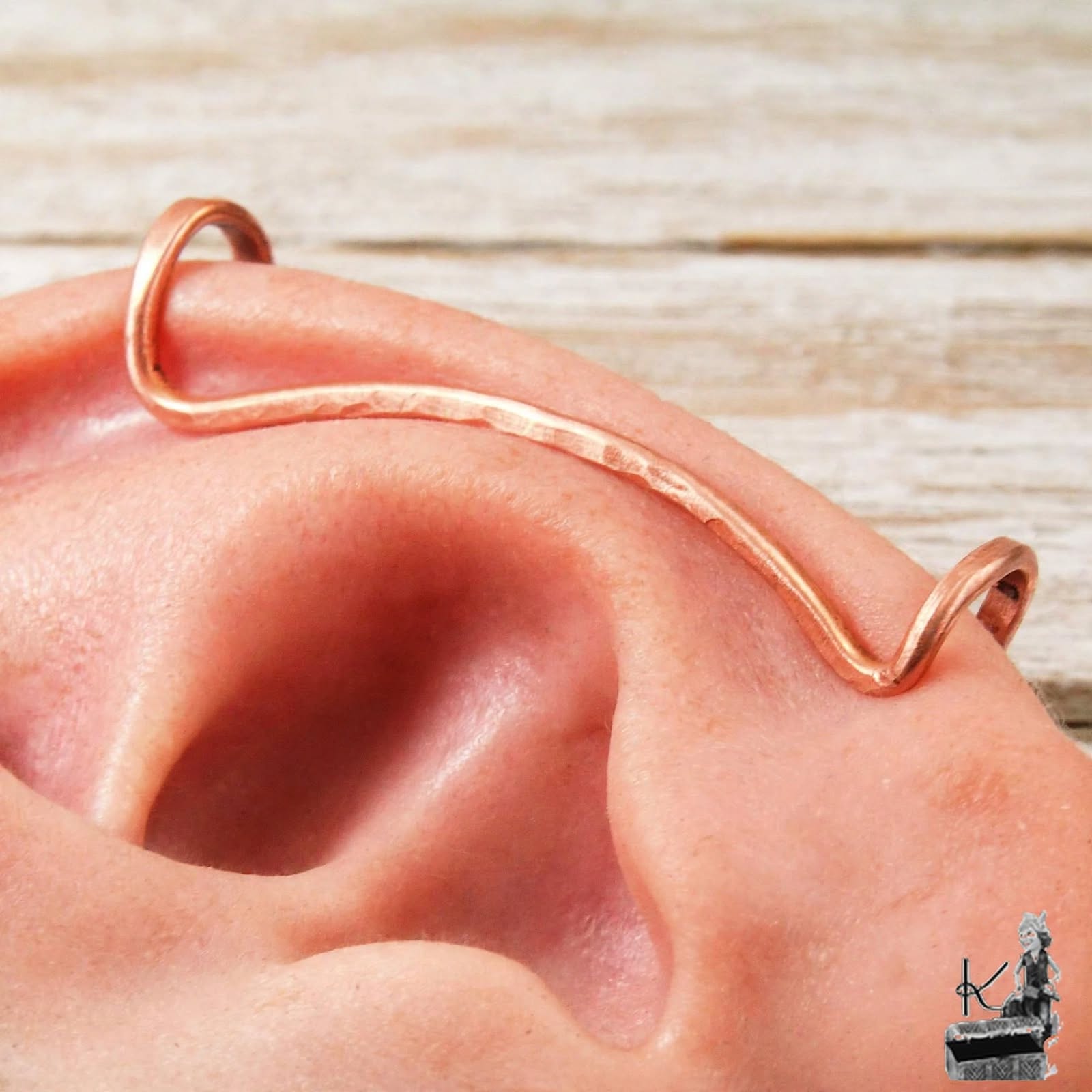 Ear cuff tour d'oreille "L'Arceau" en cuivre pur martelé, porté sur le cartilage de l'oreille.
