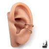 Gros plan sur un ear cuff double onde minimaliste sans perçage en cuivre pur patiné, porté sur le cartilage de l'oreille.