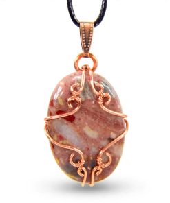 Pendentif artisanal Aourenn en cuivre wire wrapped et cabochon de brèche de chert aux motifs uniques.