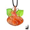 Pendentif artisanal en forme de citrouille en aventurine orange et cuivre naturel, agrémenté de feuilles et de fleurs en acrylique.