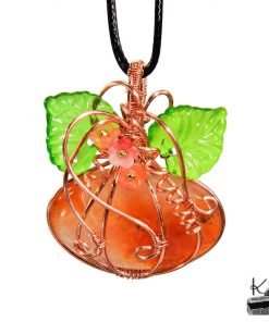 Pendentif artisanal en forme de citrouille en aventurine orange et cuivre naturel, agrémenté de feuilles et de fleurs en acrylique.