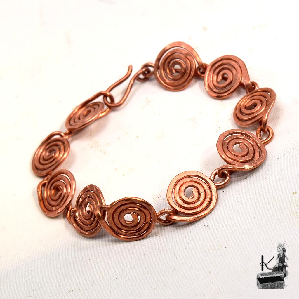 Bracelet artisanal Spiralae en cuivre naturel façonné à la main avec motifs de spirales.